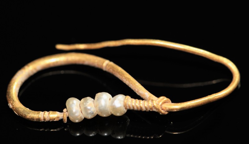 1st-3rd century AD. Gold earring with wire hoops and four pearls. In Roman socie...
