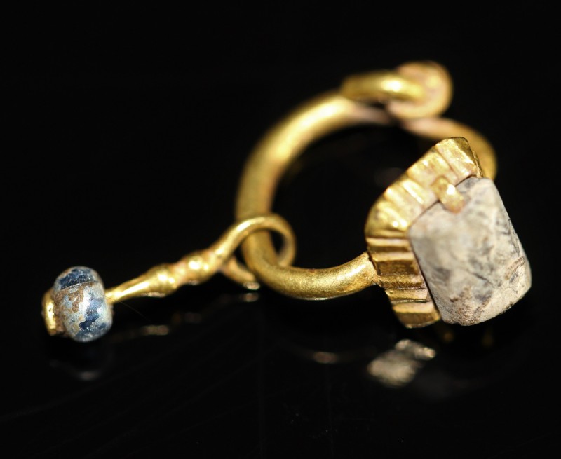 2nd-4th century AD. Gold earring with blue and white glass beads. Very fine cond...