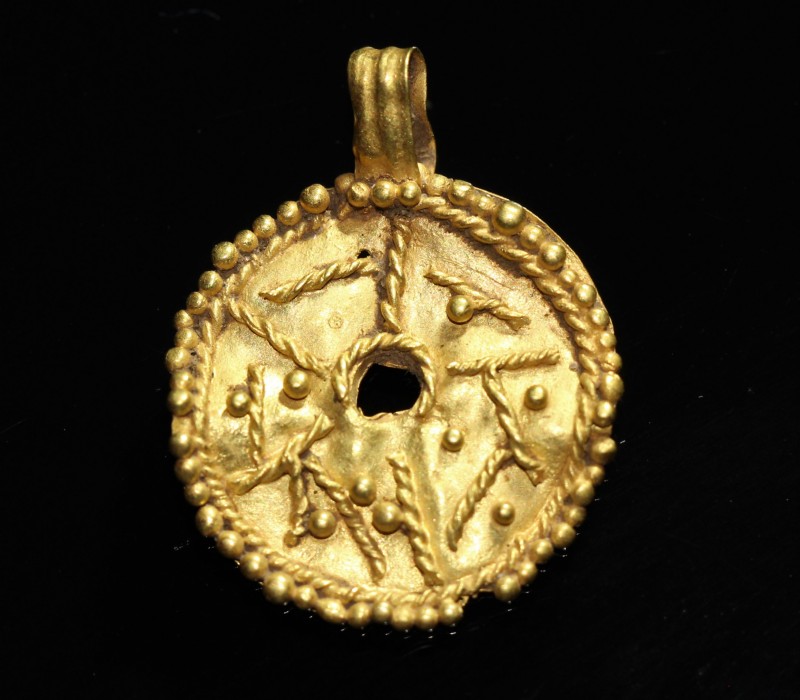 3rd-2nd century BC. Gold pendant with round shape in the image of the sun, richl...