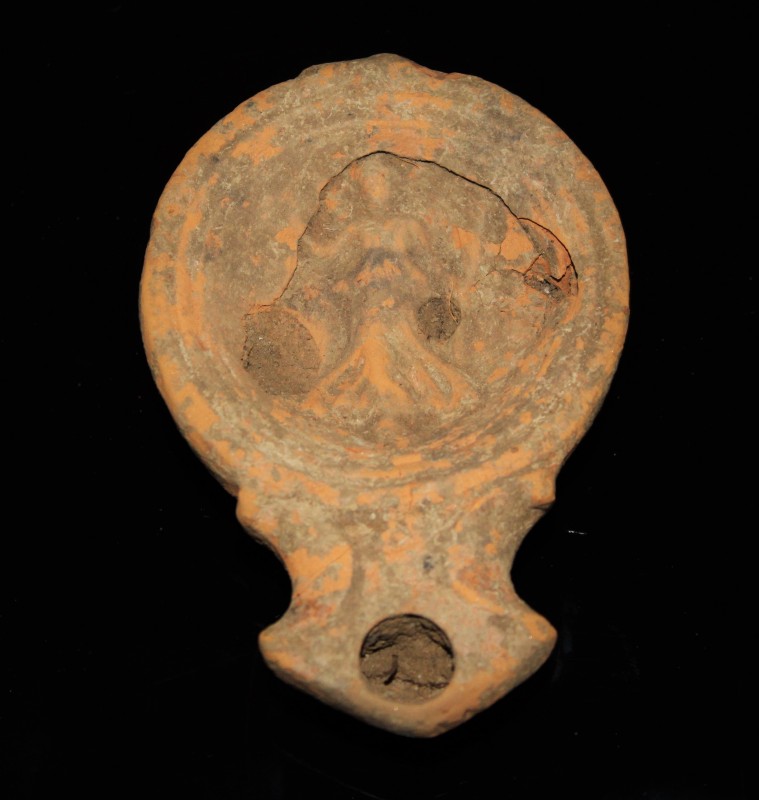 3rd - 4th century AD. A pale red terracotta oil lamp (lucerne), the surface deco...