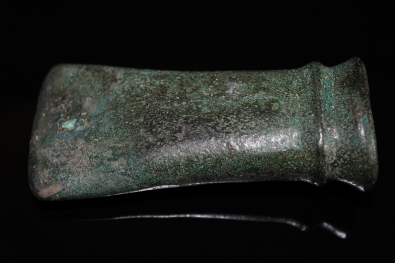 1st millenium BC. A large bronze axe head with gently curving blace, reinforcing...