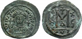 BYZANTINE.Justinian I, AE Follis. Cyzicus. 527-565 AD. DN IVSTINIANVS PP AVG, helmeted, cuirassed bust facing, holding cross on globe and shield with ...