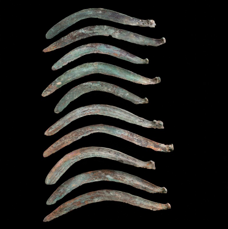 Bronze Age, lot of 11 bronze Sickle/Sword. Southern Europe, c. 1300 BC. Cast bro...