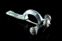 Roman Bronze Crossbow Fibula, 3rd-4th century AD (8.1cm). Heavy brooch with three knobs, long foot decorated with pellet-in-circle designs. Intact wit...