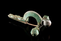 Roman Bronze Crossbow Fibula, 3rd-4th century AD (7.8cm). Heavy brooch with three knobs, decorated with chain pattern. Nice green patina, intact with ...