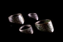 Lot of 4 Byzantine Bronze Archer's Rings with convex triangular extension decorated with incised scrolled designs and central ovoid motif. c. 10th-14t...