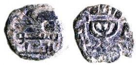 UMAYYAD COIN DEPICTING A MENORAH Post-reform, ca. 715 CE. Bronze 14.1 mm. Obverse: Five-branched Menorah. Reverse: Arabic inscription: "There is no Go...