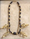 A GARNET AND GOLD BEADS NECKLACE Iron Age II, 8th-7th century BCE. 41 cm long. Including 4 gold animal headed cage pendants. In very good condition an...