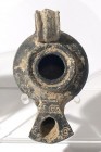 A BLACK TERRACOTTA OIL LAMP Herodian Period, 1st century CE. 10.1 cm. In very good condition. Ex Judge Steve Adler collection, Jerusalem.
