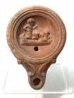 AN EROTIC TERRACOTTA OIL LAMP Roman Period, 1st-2nd century CE. 10.6 cm. The surface is in very good condition and the base is damaged. Ex Shlomo Mous...