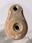 A BEIT-NATIF TYPE CLAY OIL LAMP 4th century CE. 8.2 cm. Decorated with a large leaf. In very good condition. Ex Judge Steve Adler collection, Jerusale...
