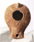 A RED SLIP CLAY OIL LAMP 4th-5th century CE. 9.8 cm. Decorated with an amphora, 2 grapes and 2 birds. In good condition. Ex Judge Steve Adler collecti...