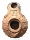 A SAMARITAN TERRACOTTA OIL LAMP 4th century CE. 9.3 cm. Decorated with weapons: 2 daggers, 2 axes and 2 chariots. In very good condition. Ex Shlomo Mo...