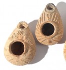 A LOT OF 2 TERRACOTTA OIL LAMPS Byzantine Period, 5th-7th century CE. 6.8, 6.7 cm. One decorated with a cross flanked by 2 birds and the second one is...