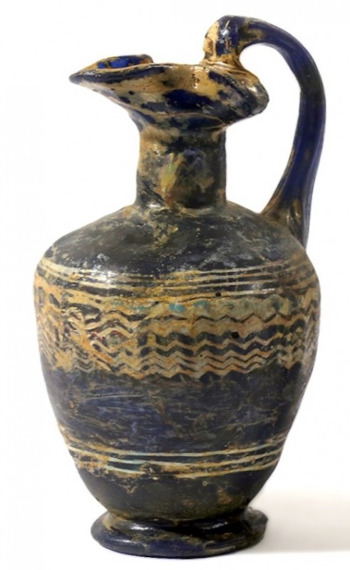 A SAND-CORE GLASS OINOCHOE 4th-3rd century BCE. 12.3 cm high. Restored but in fa...