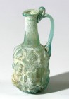 A SMALL SIDONIAN GLASS FLASK Roman Period, 1st century CE. 9.6 cm high. Blown in a three-parts mold, depicting 6 amphorae. With a crack at the base bu...