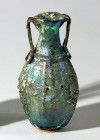 A SMALL SIDONIAN GLASS FLASK Roman Period, 1st century CE. 8.9 cm high. Blown in a two-parts mold, basket-like with floral motifs. Rim and handle repa...