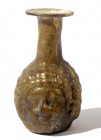 A HONEY-YELLOW GLASS JANUS-HEAD FLASK Roman Period, ca. 4th century CE. 8.9 cm high. In very good condition. Ex David Bergman collection, Haifa.