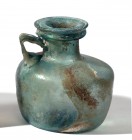 A CYLINDRICAL GLASS BOTTLE Late Roman Period, 4th century CE. 12.5 cm high, 11.9 cm in diameter. In very good condition.