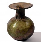 AN OLIVE GREEN GLASS SPRINKLER Roman Period, 3rd-4th century CE. 9.8 cm high. Body with diagonal ribbing. In very good condition. Ex Yoav Sasson colle...