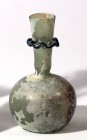 A GLASS BOTTLE Byzantine Period, 4th-5th century CE. 10.7 cm high. With a wavy turquoise neck decoration. In very good condition. Ex Shlomo Moussaieff...