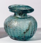 A GREENISH GLASS JAR Byzantine Period, 4th-5th century CE. 8.3 cm high. With spherical ribbed body blown in a mold. Ex Amiram Aharonowitz collection, ...