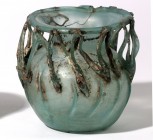 A GLASS JAR WITH RIBBED BODY AND ZIGZAG DECORATION Byzantine Period, 4th-5th century CE. 10.3 cm high. The upper part is repaired from several pieces....
