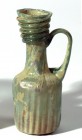 A GLASS JUGLET WITH RIBBED BODY Byzantine Period, 4th-5th century CE. 11.2 cm high. In very good condition. Ex Yoav Sasson collection, Jerusalem.