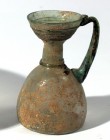 A TRANSLUCENT GLASS JUGLET Byzantine Period, 4th-5th century CE. 9.9 cm high. With dark green handle. In very good condition. Ex David Bergman collect...