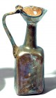 A SQUARE TRANSLUCENT GLASS JUG 6th-7th century CE. 13.3 cm high. Blown in a mold, depicts stylized palm frond, vertical lines and diagonal stripes. Wi...
