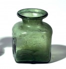 A CHRISTIAN SQUARE GLASS JAR Byzantine Period, 5th-6th century CE. 7.6 cm high. Two sides decorated with an inverted palm branch and two sides and the...
