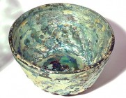 A GREEN GLASS RIBBED BOWL Islamic Period, 8th-9th century CE. 11.8 cm in diameter. With very nice silver and gold patina and in very good condition. E...