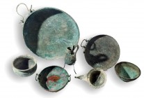 A HOARD OF 7 BRONZE VESSELS Late 13th – early 12th century BCE. 3 dishes with handles (one decorated), 28.5, 18.2, 13.8 cm in diameter, 2 drinking bow...