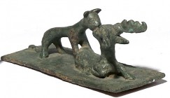 A BRONZE PLAQUE DEPICTING A FELINE ANIMAL ATTACKING A STAG Parthian, 2nd century BCE-CE. 13.6 cm long, 5.1 cm max in height. With nice black patina an...