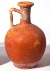 A RED SLIP TERRACOTTA DECANTER Roman period, 4th century CE. 23.3 cm high. In very good condition.