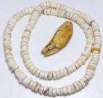 Précolombien - Collier en perles de coquillage
Grand collier en perles de coquillage orné en son milieu d'une dent en ivoire. 520 mm.