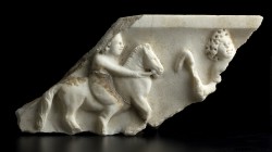 Relief with scene from the October Horse
Early 2nd century AD; alt. cm 12 ; A relief with a putto riding a horse towards the right; opposite is a sec...