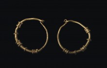 Pair of Roman gold earrings
1st – 2nd century AD; diam. mm 16; Pair of gold earrings with circular section profile, hook clasp and small beads decora...
