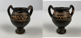 Greek miniature krater. A ceramic blackware miniature bell krater with flared rim and strap handles, both faces with red applied geometric motifs. 5th...