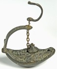 OBJEKTE AUS BRONZE. 
GEFÄSSE. 
Öllampen. Öllampe, byzantinische Bronze-Hängelampe, ovale Form, auf dem Spiegel Büste mit langem breiten Bart in Glor...
