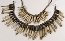 OZEANIEN. 
NEUGUINEA. 2 Ketten aus Hundezähnen (Papua Neuguinea), auf Bastband geknüpft 30 Stück L.5cm bis 7,5cm, 24 Stück L.3,8cm bis 5,8cm. Opitz&n...