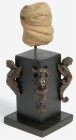 AFRIKANA. 
NIGERIA. 
NOK. Köpfchen mit ovalen Augen und breitem Mund, brauner Ton, H.55mm, gestielt auf Holzständer, an den Ecken geflügelte Figuren...