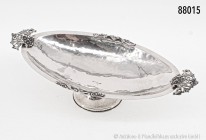 Silberne Konfektschale, Italien, ca. 1920, 800er Silber, "battuto a mano" (Handarbeit). 278 g, L 31 cm, B 15 cm, H 7 cm. Floraler Dekor an den Henkeln...