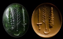 A roman green chalcedony intaglio. Military allegory. Inscriptions.
2nd century A.D.
9 x 12 x 4 mm

On the main surface: the Hercules club, a palm...