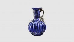 A Roman blue ribbed glass jug. Second half of the 1st century AD. 7.9cm high. From an esteemed American collection; former Geoffrey Sowas collection, ...