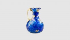 A Roman blue glass jug. 1st century AD. 4.4cm high. From an esteemed American collection