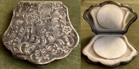 Portacipria in argento a forma di conchiglia con incise decorazioni floreali, prima metà sec. XX. Con specchio e spugnetta. 
Misure mm. 81x72
