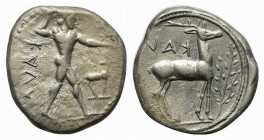 Bruttium, Kaulonia, Stater, ca. 475-425 BC. AR (g 7,90; mm 22; h 3). KAVΛ (retrograde), Nude Apollo walking r., holding branch, holding small running ...