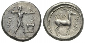 Bruttium, Kaulonia, Stater, ca. 475-425 BC. AR (g 7.89, mm 20, h 3). KAVΛ (retrograde), Nude Apollo walking r., holding branch, holding small running ...