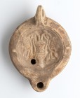 Roman Oil Lamp with Kantharos and Flowers, 1st - 2nd century AD; height cm 4,7, length cm 12,3; Stamp on rear. Provenance: From the collection of a Di...